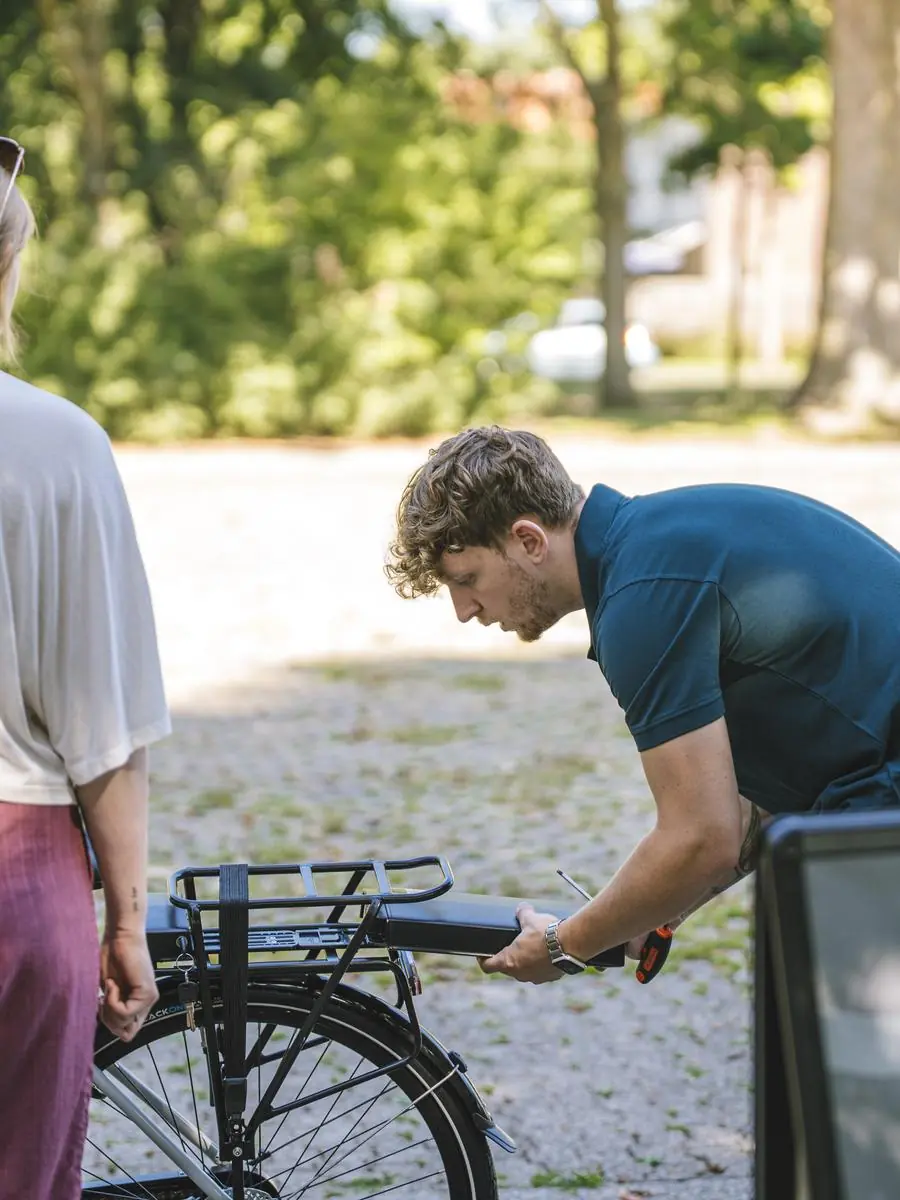 Een teamlid stelt de e-bike af voor een deelnemer